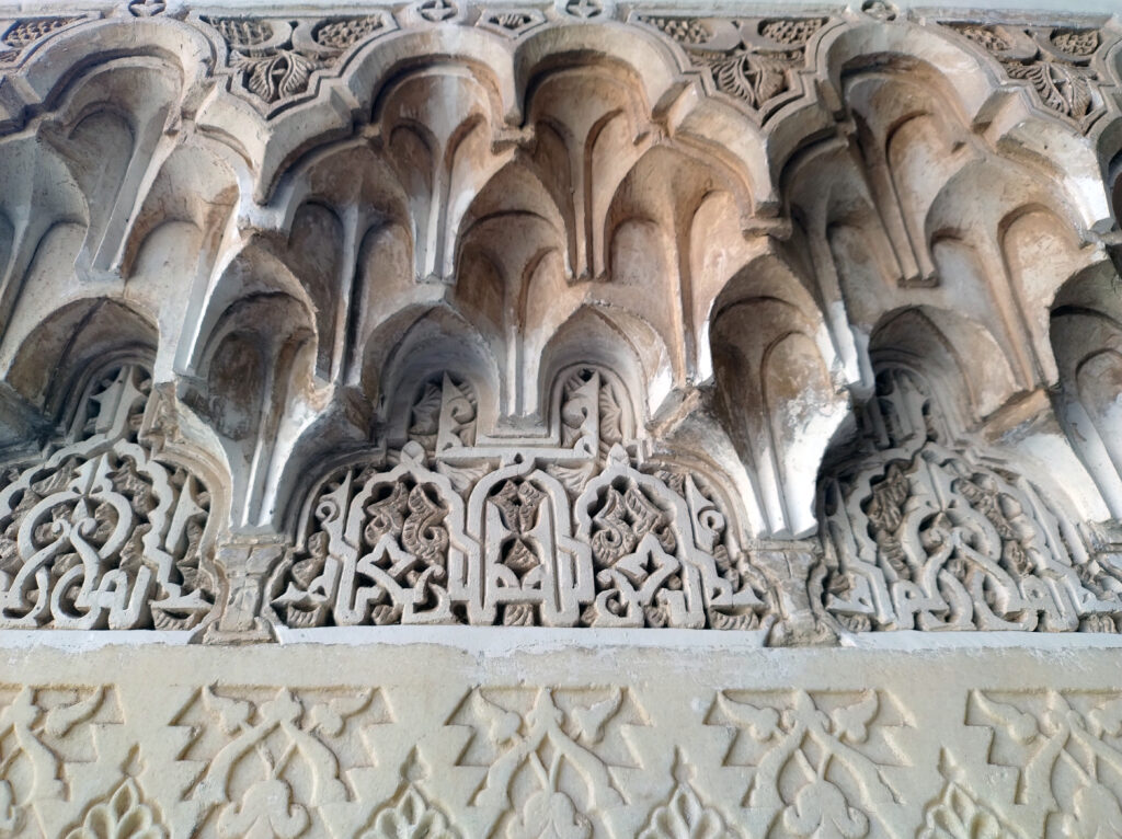 La Medersa. Particolare degli arabeschi e dei muqarnas: decorazioni tridimensionali che usano per abbellire gli spessori degli archi e le profondità dei muri.